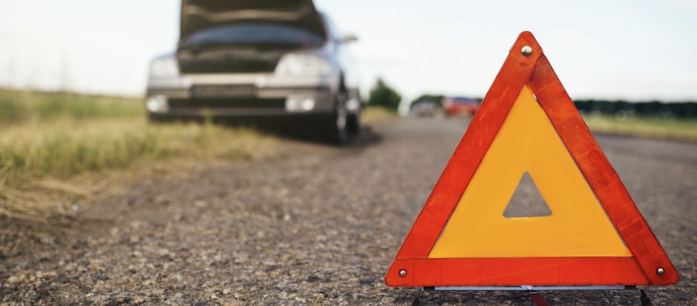 Roadside assistance warning triangle with broken down car in North Babylon, NY